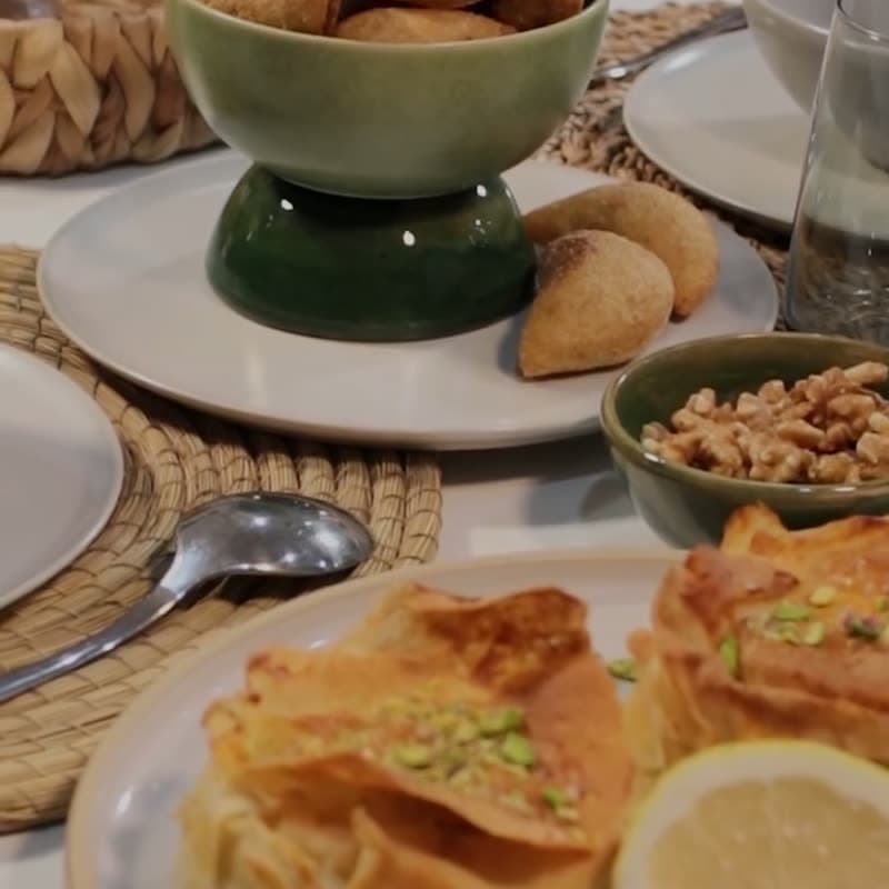 Briouates dorées et bol de fruits secs dressés sur une table
